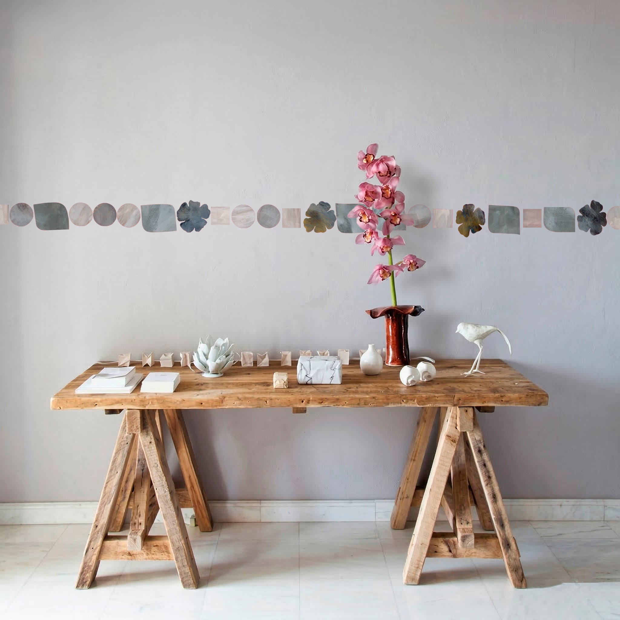 grey hand painted peel and stick wallpaper border with geometric shapes and flowers