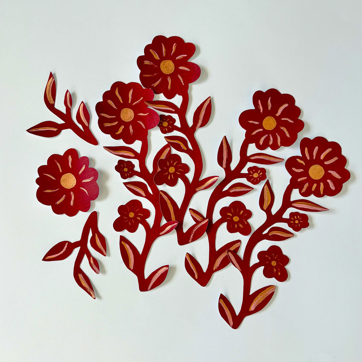 Sæt af håndmalede røde og gyldne blomster wall stickers arrangeret som en blomstergren, klar til at blive sat op som tapetbort